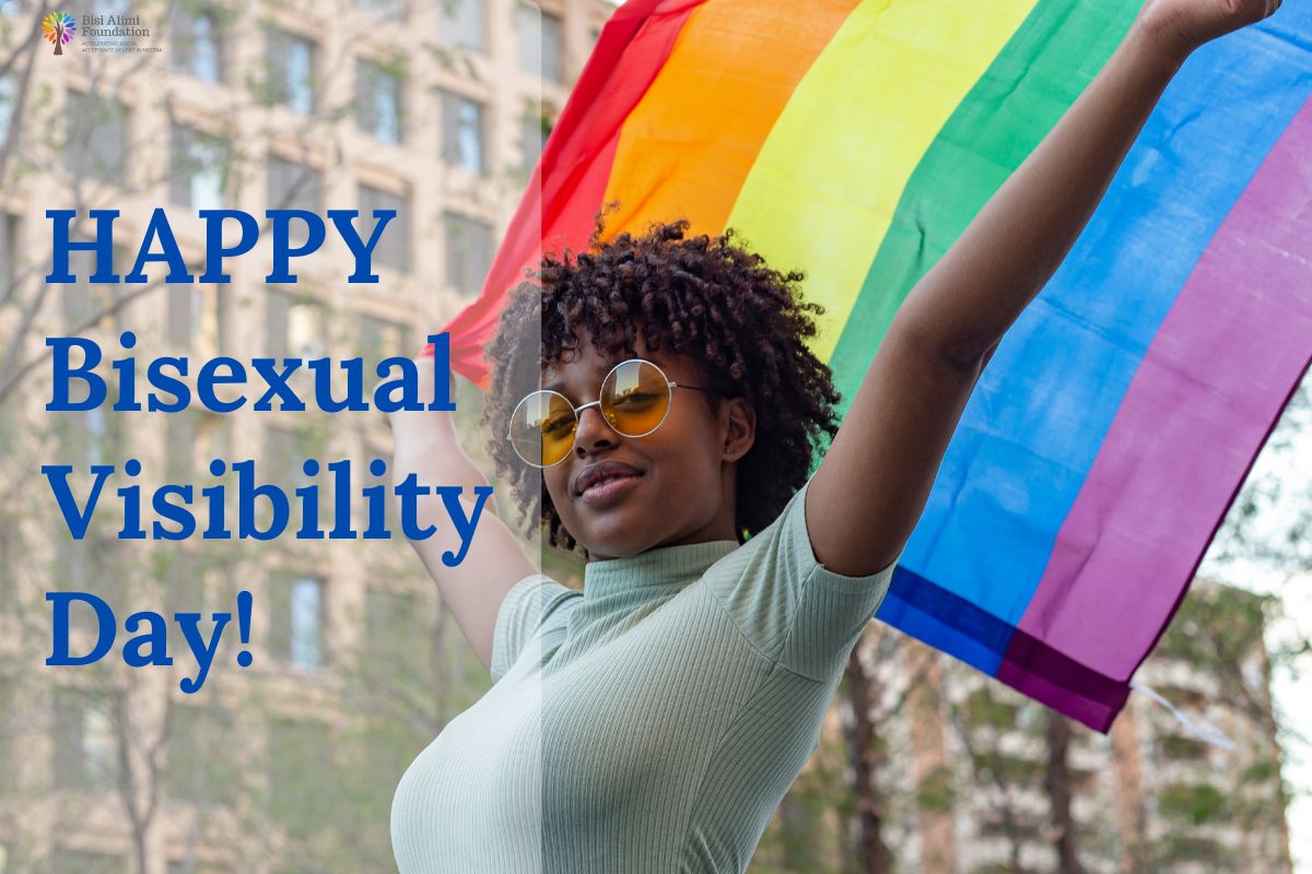 A black woman holding up a rainbow flag